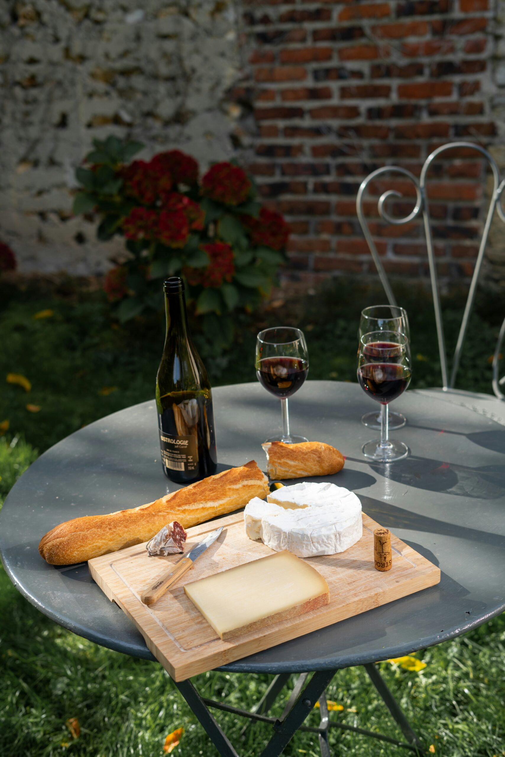Table with French cheeses, wines, and baguettes